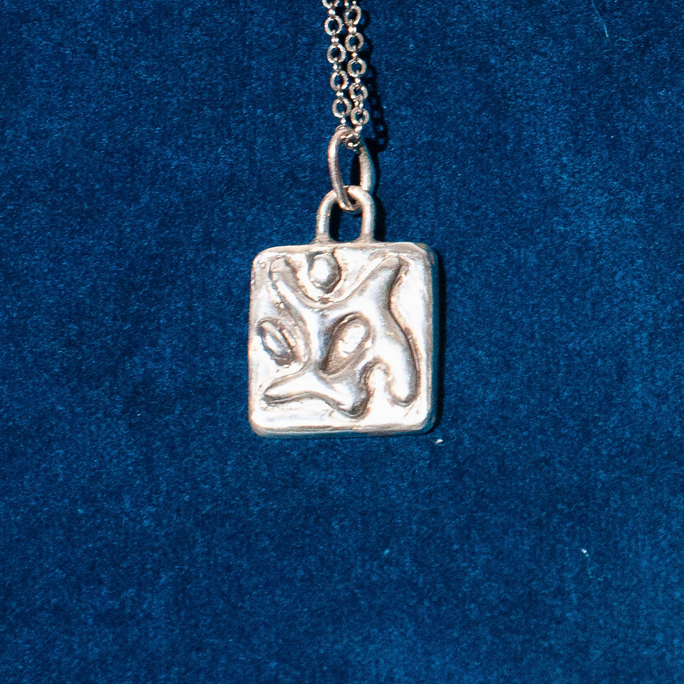 Silver pendant on a chain on a dark blue background.