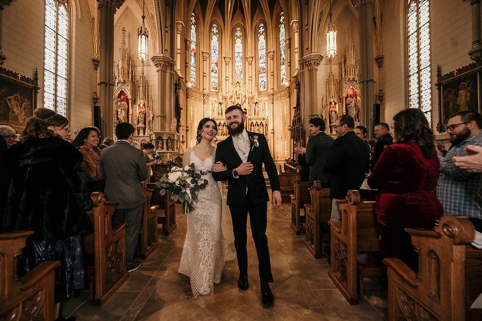 a bride and groom walking down the aisle of a catholic church after getting married
