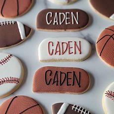sugar cookies with a sport theme. Cookies that look like an American football, a basketball and a baseball. And cookies with the celebrants name that are designed in the matching colors of the balls.