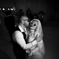 Happily married couple sharing a fun kiss during their wedding reception at a Las Vegas banquet hall — joyful celebration moment