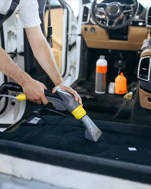 Professionnel du nettoyage intérieur de camion passant l’aspirateur dans l’habitacle
