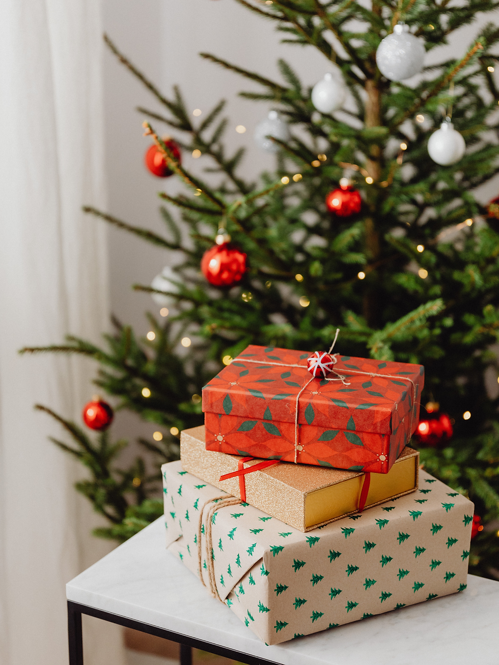 Holiday gifts in front of a Christmas tree