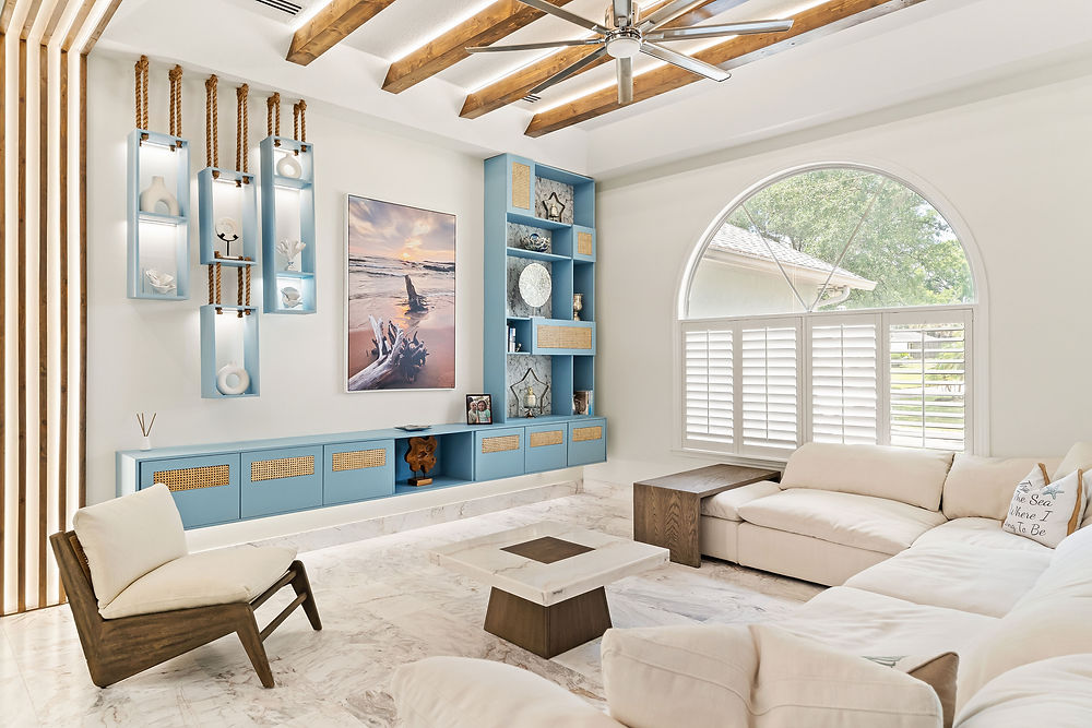 Modern living room with blue built-ins, white sofa, and arched window.
