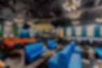 Vibrant restaurant interior with blue booths and orange seating
