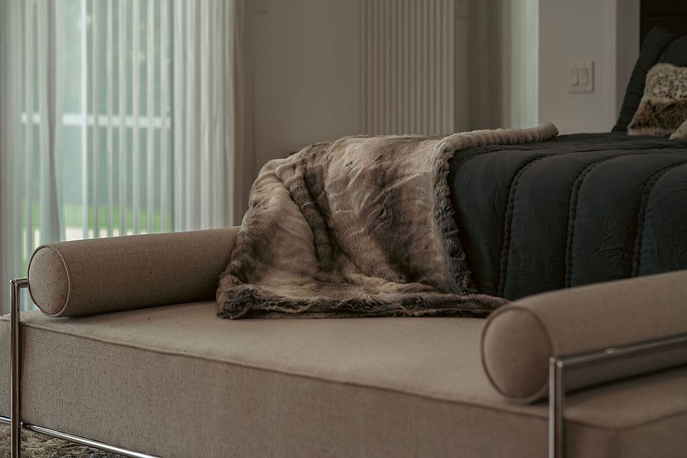 Bedroom with textured throw blanket on bench