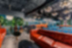Stylish lounge with red sofas, blue seating, and modern lighting