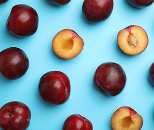 Delicious ripe plums on light blue backg