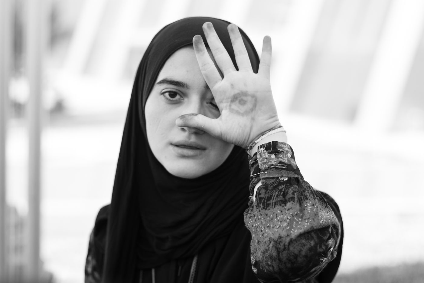 Artistic portrait of a hijab lady with henna in her hand.