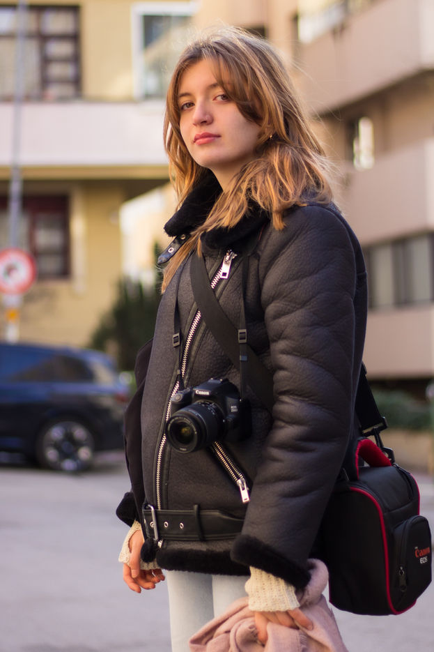 Portrait of a woman under soft sunlight in street.