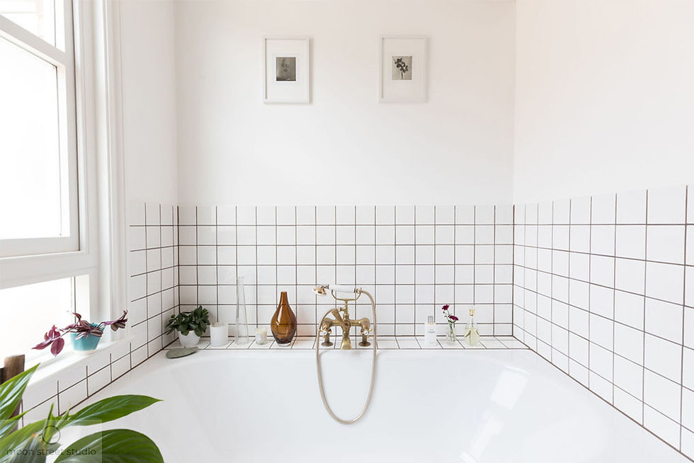 Beautiful brass tapware and carefully selected decorative items add a luxurious touch to this fresh white bathroom. Renovation by Absolute Project Management.