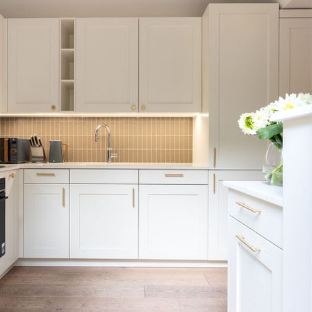 Kitchen with white shaker doors and taupe splashback tiles