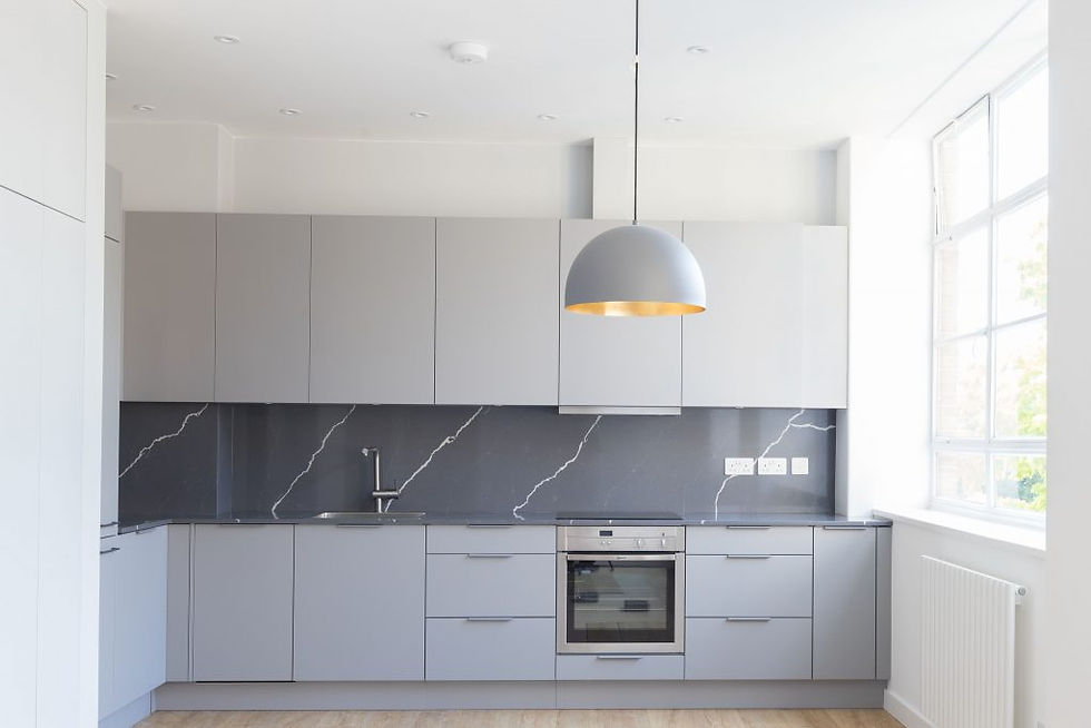 Soft grey kitchen cabinetry with a darker worktop and modern fittings keep this space contemporary. Renovation by Absolute Project Management.