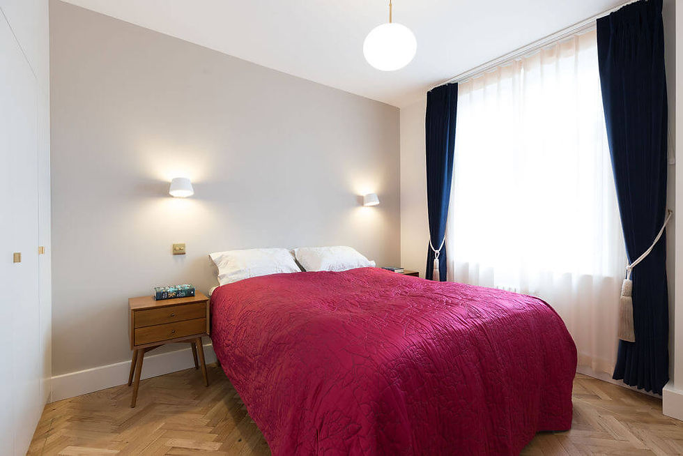 Bedroom with parquet floor, grey feature wall and blue velvet curtains - renovation by Absolute Project Management