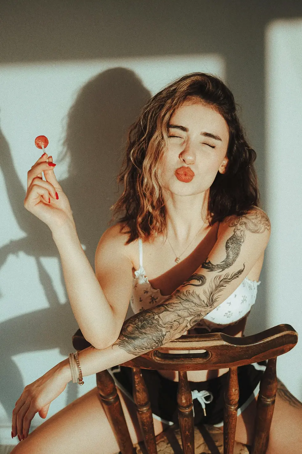 Leah, a Scottsdale stripper posing on a chair hold a lollipop