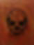 Rot-oranges Kunstwerk mit einem einem grossen Totenkopf in der Mitte