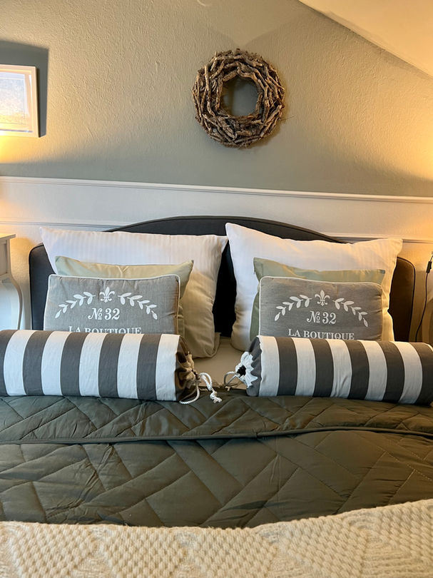 Schlafzimmer mit dekorativen Kissen und Holzelementen in der Ferienwohnung Wettringen