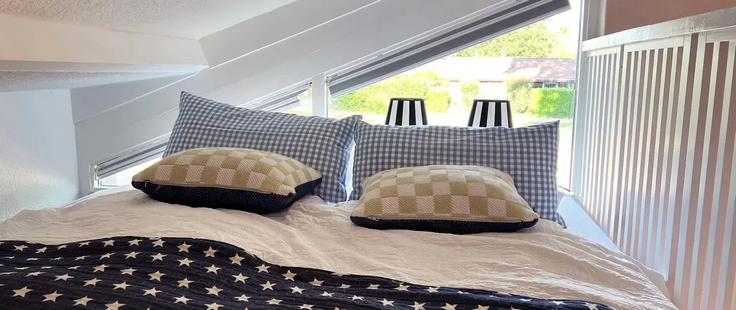 Schlafempore der Ferienwohnung Malibu S mit Doppelbett, genutzt als Schlafzimmer.