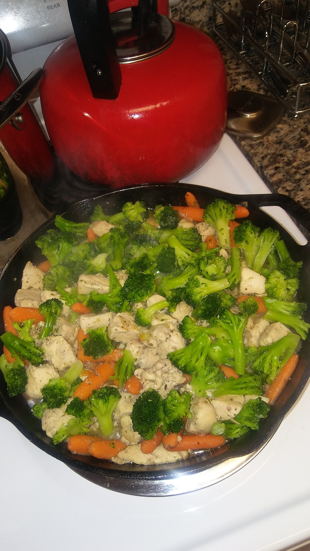 Chicken and vegetable stir fry with carrots, broccoli, and herbs
