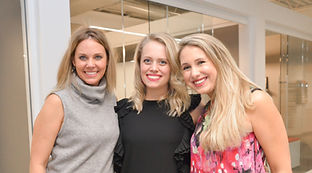 Courtnay, Megan, and Katie pose for a photo with a bright office background.