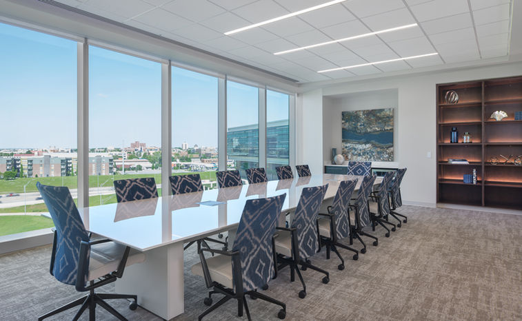 Modern conference room with large windows overlooking a cityscape view.