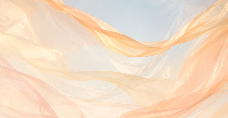 Light peach fabric flowing in the wind against a blue sky
