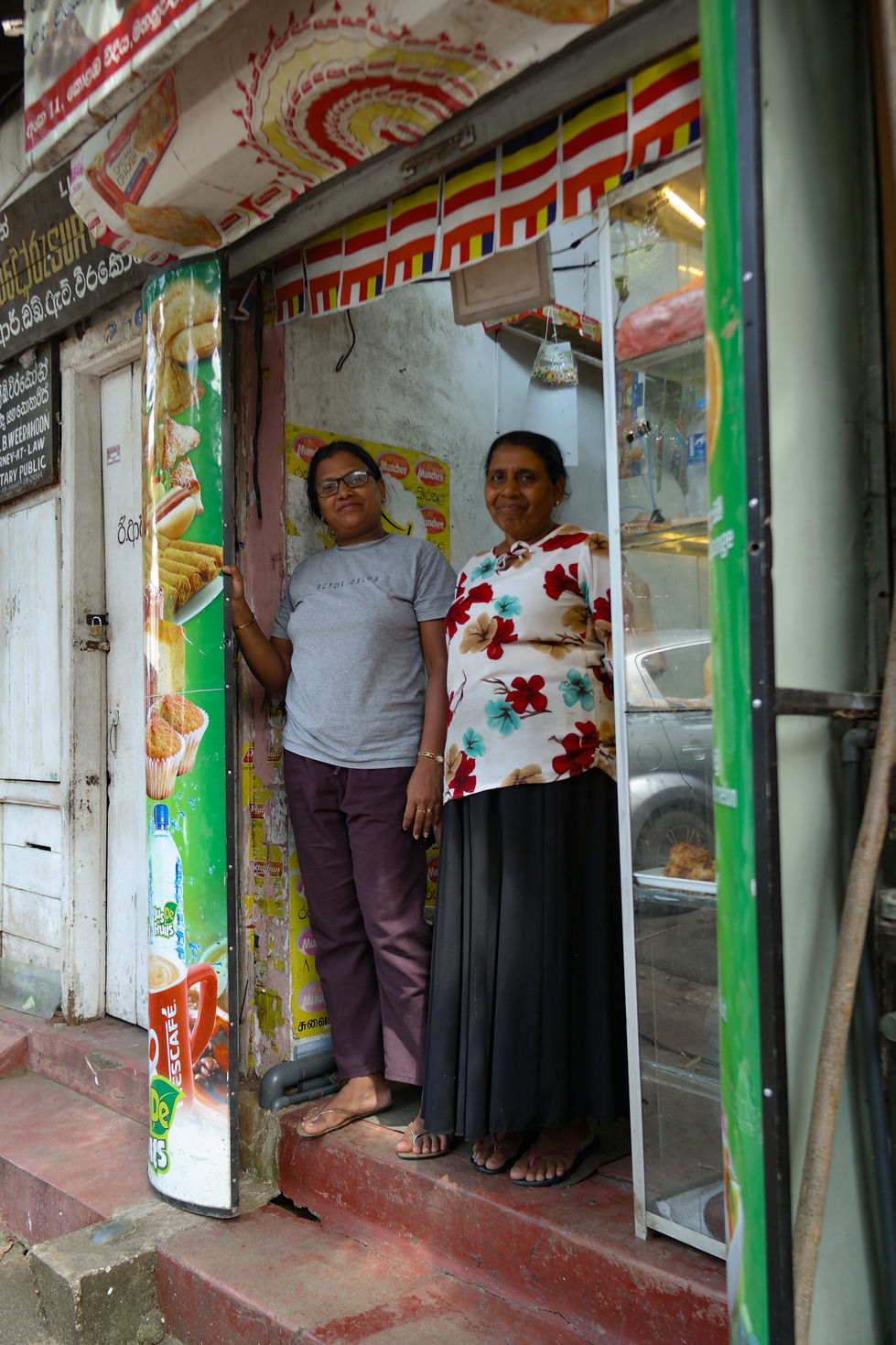 mother and daughter smiling outside their shop in Kandy, Sri Lanka
