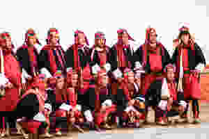 A line-up of Bhutanese warriors at the Punakha Festival, in helmets, wearing swords and dressed in their bright red uniform woven from yak-hair