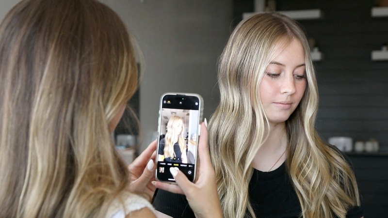 a woman taking a picture of another woman with her phone