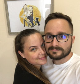 A fiatal pár boldog a mögöttük lévő képkeretben lévő karikatúrától