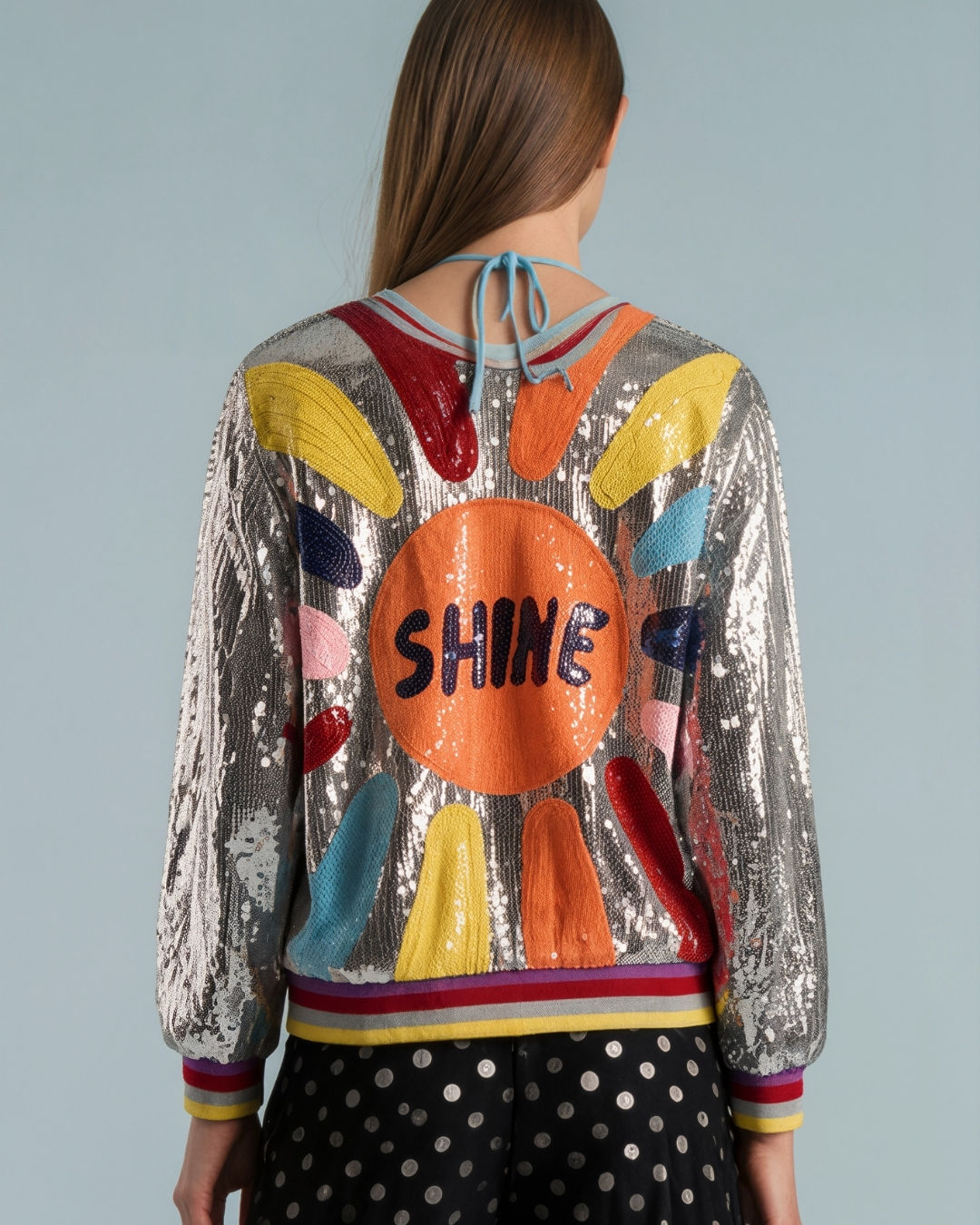 Back detail view of the Shine On sequin bomber jacket on model in studio showing back pattern with SHINE text detailing
