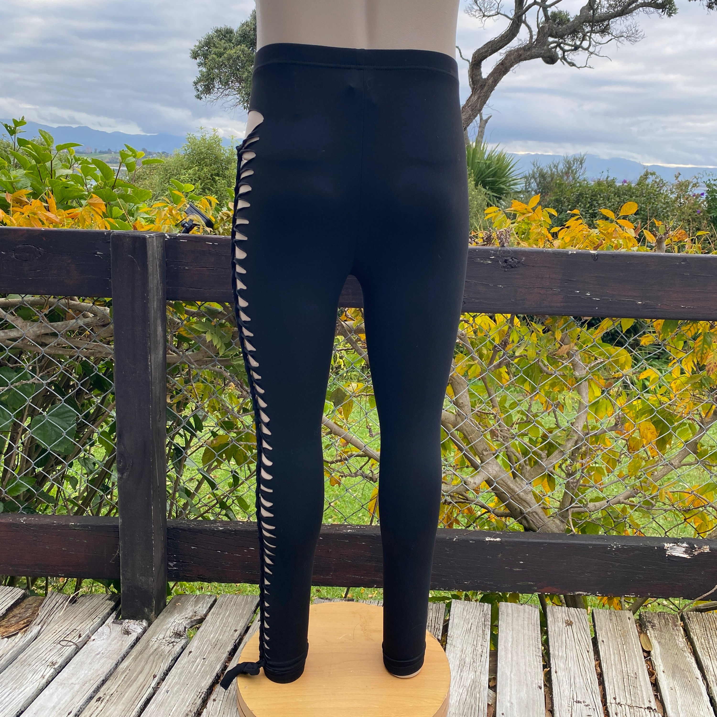 Back view of the Slit Weave Unisex Leggings on mannequin in outdoor setting
