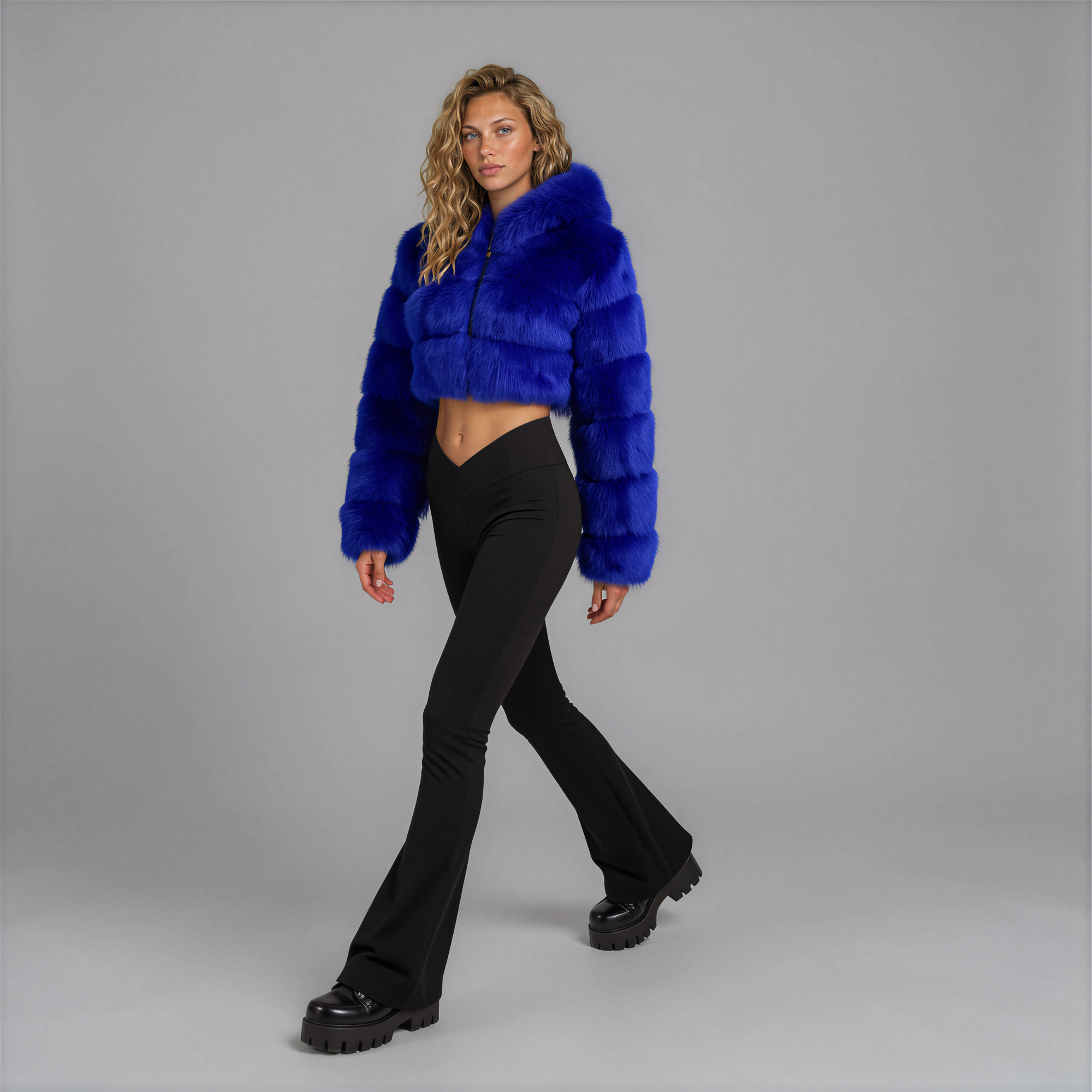 Front view of the Sapphire Muse cropped faux fur jacket on model with zip up and hood down