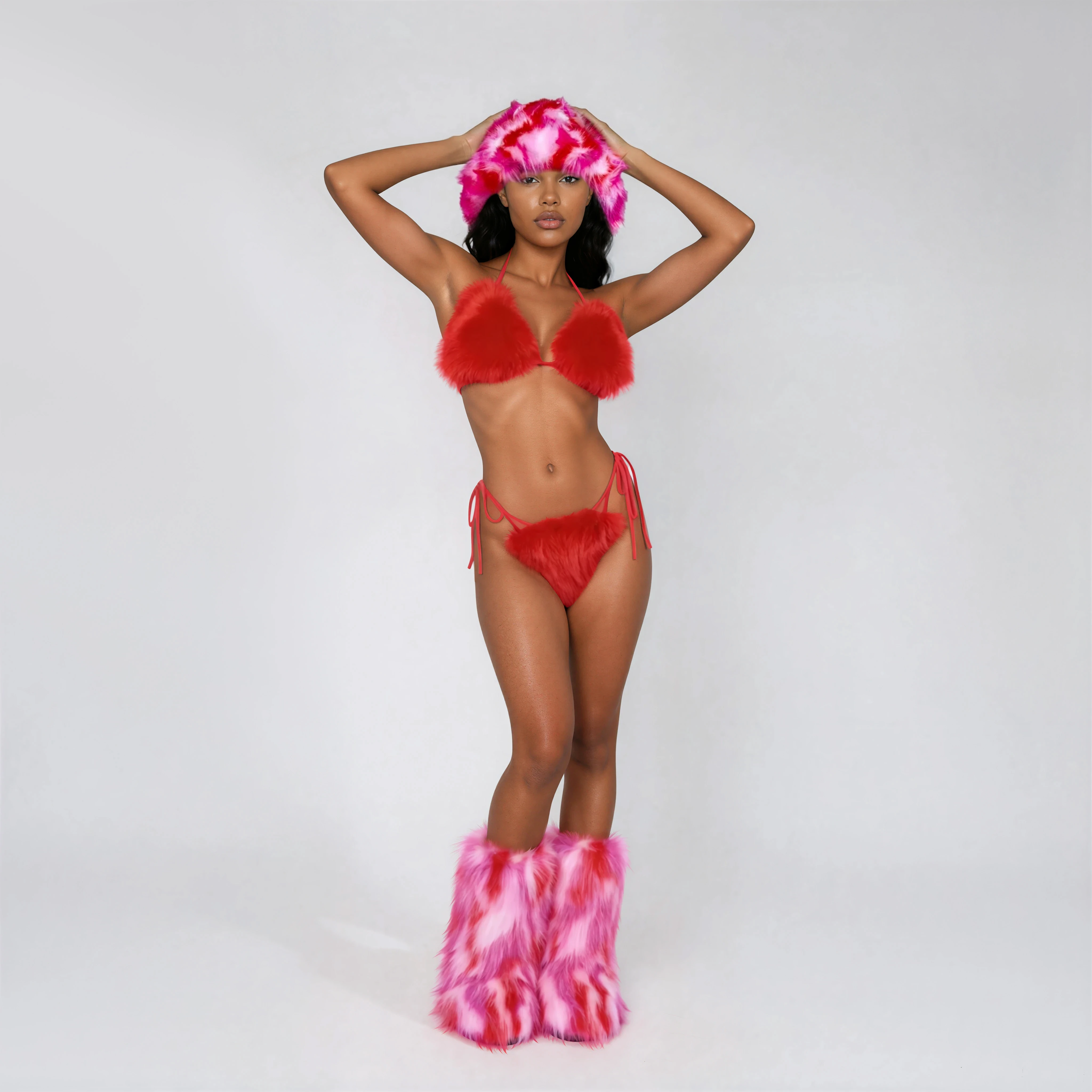 Front view of red fur rave bikini on model in studio styled with fur hat and fur boots