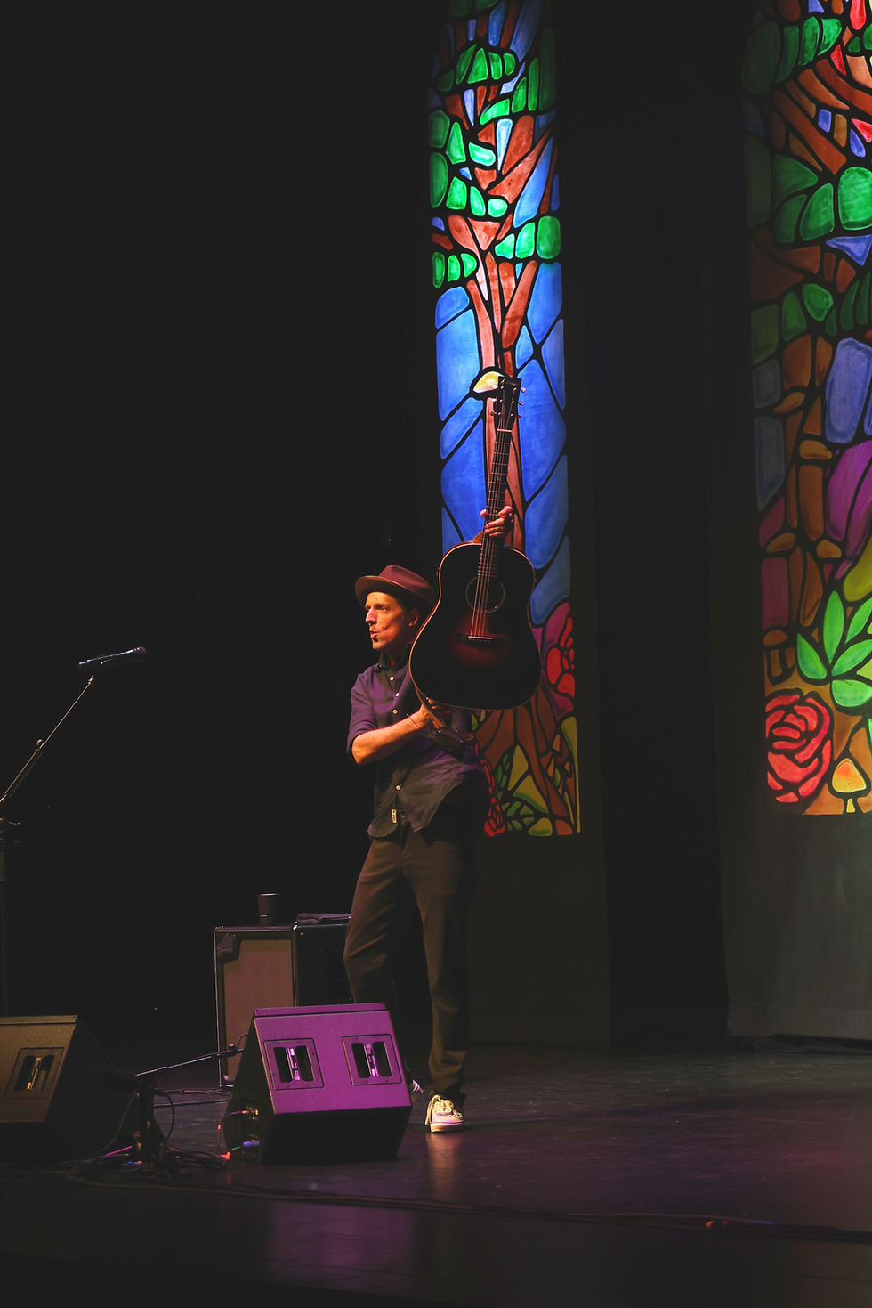 Jason Mraz raising guitar