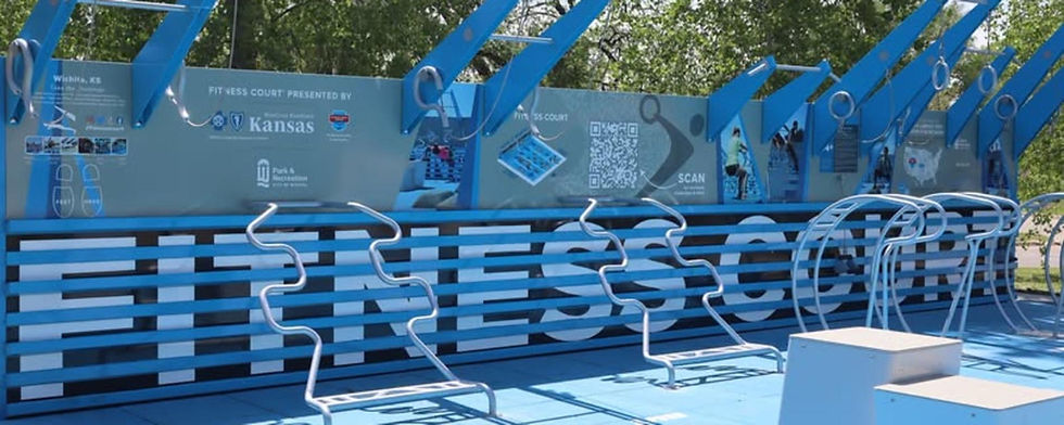Circuito fitness azul al aire libre en Wichita, Kansas, con anillas, QR y paneles informativos bajo árboles.