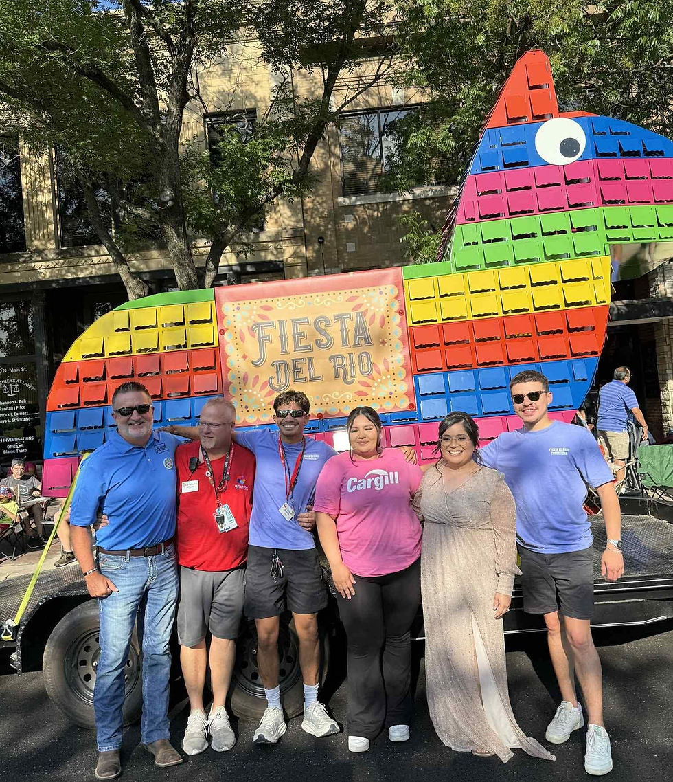 Six people in front of a colorful, giant piñata.