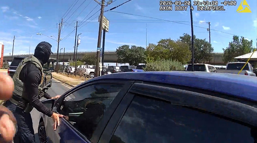 Policía encapuchado junto a un coche azul en una calle soleada; video corporal con sello AXON y fecha/hora arriba.