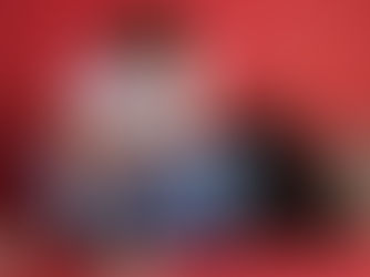 Leonel Messi baña a un bebé en una tina azul sobre fondo rojo; hay toallas, un pato de juguete y jabón, escena tierna.
