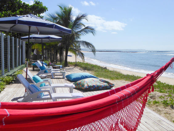 Rede vermelha em deck com vista para o mar
