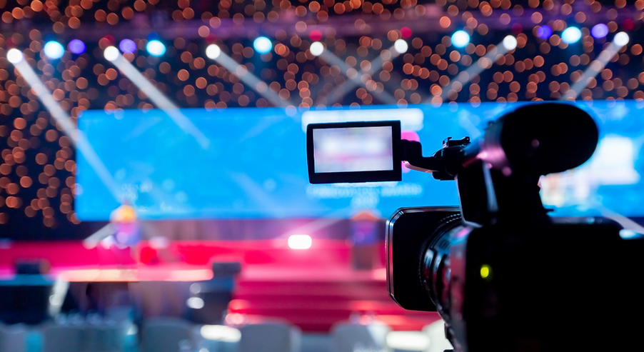 A photo of a professional video camera on a large conference stagetage