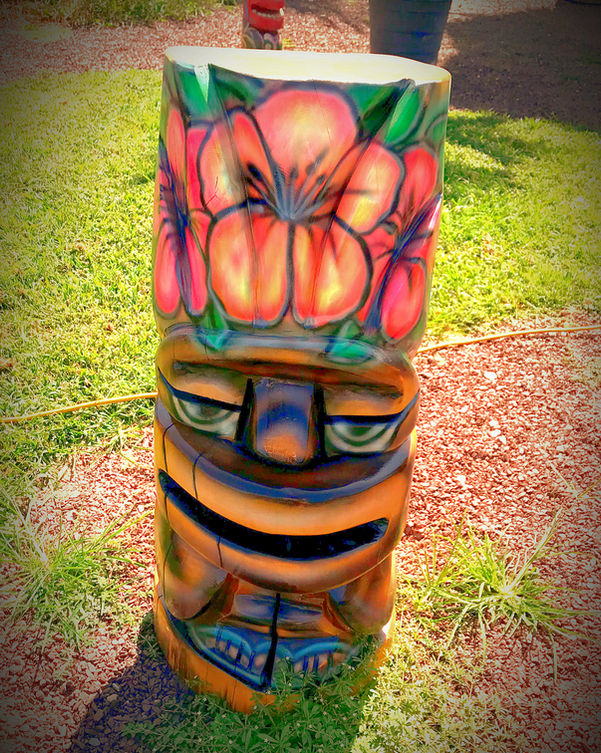 Tiki Murph carved pine full body round tiki with large pink flowers.