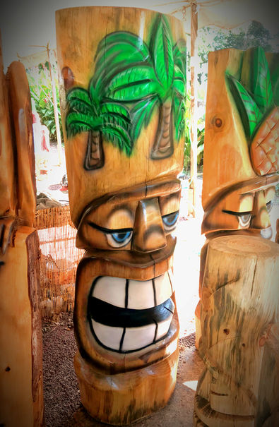 Tiki Murph carved pine half smiling tiki with relief carved palm trees.