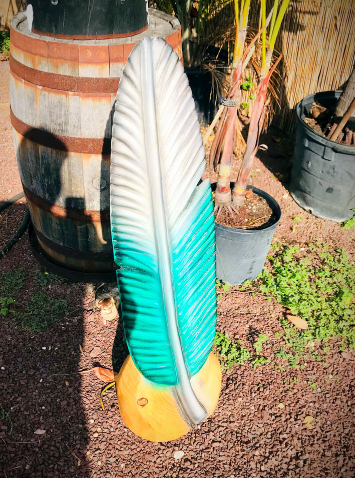 Tiki Murph chainsaw carving white pine feather in Philadelphia Eagles colors