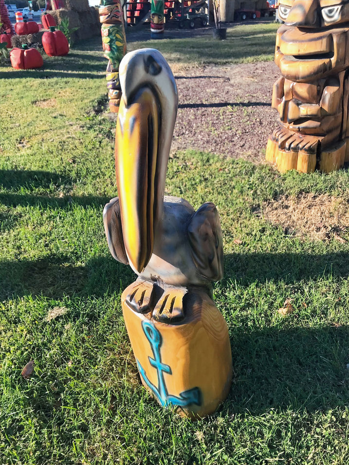 Tiki Murph white pine chainsaw carved pelican on a stump with a painted nautical anchor