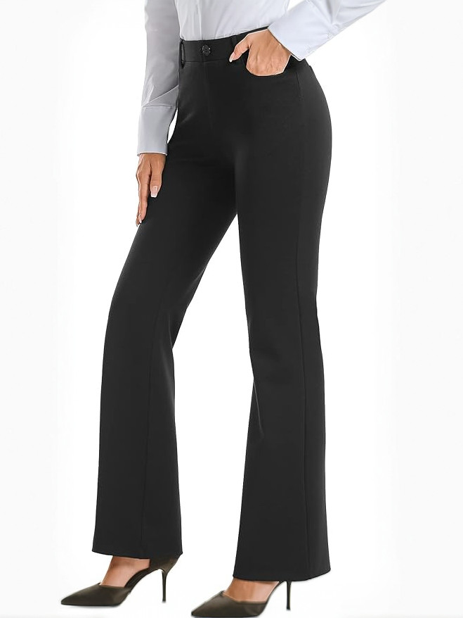 Woman modelling black bootcut dress pants and sleek high heels.