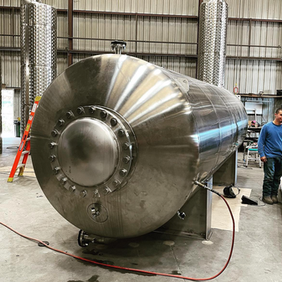 Large horizontal stainless steel tank in a factory facility