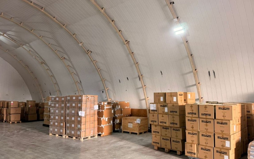 Palletized cargo and boxes insides of a PLP hangar by the wall