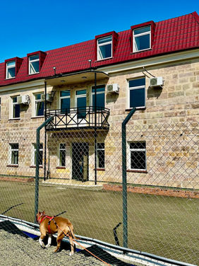 PLP three store Administration building with burgundy roof on a sunny day.
