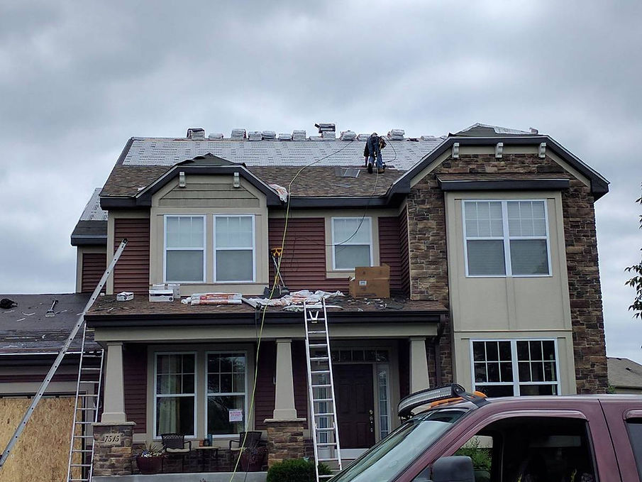 Contruction workers renovating a house with siding services and roofing services..
