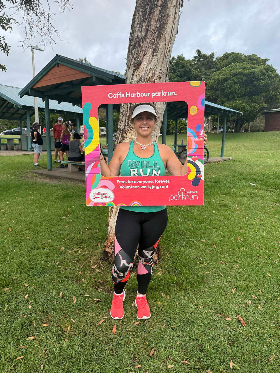 Chooky at Coffs Harbour, NSW, holding a parkrun frame during a parkrun tourism visit